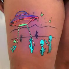 an alien tattoo on the back of a woman's thigh