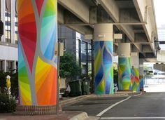 an empty street with colorful painted columns on both sides and a traffic light in the middle