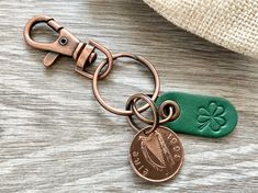 a key chain with a penny and clover on it