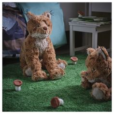 two stuffed animals are sitting on the green carpet