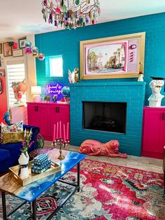 a living room filled with furniture and a fire place under a chandelier hanging from the ceiling