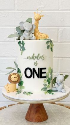 a white cake decorated with animals and greenery