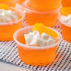 orange jello shots in plastic cups with whipped cream