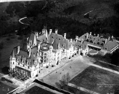 an aerial view of a large building with many windows and towers on it's roof