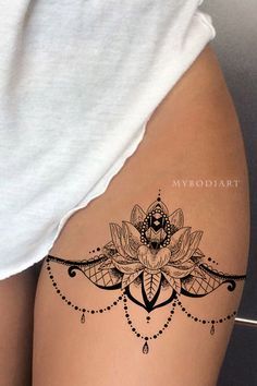 a woman's thigh with a tattoo design on the leg and an image of a lotus