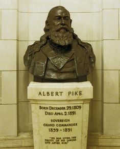 the bust of albert pike is on display in front of a white wall with black writing