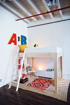 there is a loft bed with a ladder on the bottom and a desk underneath it