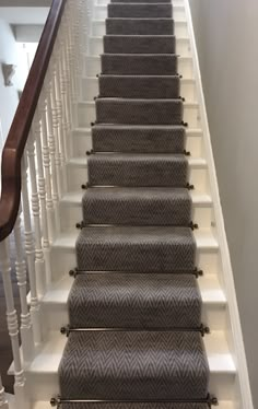 an image of a staircase with carpet on the bottom and handrails down it