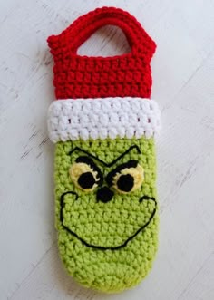 a crocheted cell phone case with a grin face on it's side