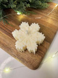 a white snowflake ornament sitting on top of a wooden cutting board