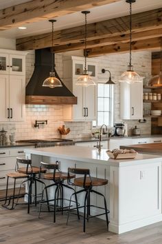 a large kitchen with white cabinets and wooden beams on the ceiling, along with bar stools