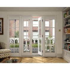 an open living room with french doors and bookshelves on either side of the glass door