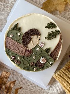 a decorated cake sitting on top of a table next to autumn leaves and acorns