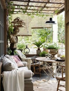 an outdoor living area with wicker furniture and potted plants