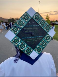 a person wearing a graduation cap with writing on the front and back of their hat