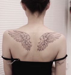 the back of a woman's shoulder with wings on it