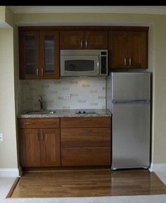 an empty kitchen with wooden cabinets and stainless steel appliances