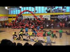 a group of people standing on top of a basketball court in front of an audience