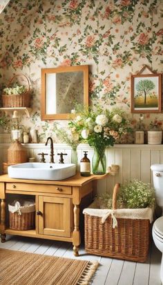 a bathroom with floral wallpaper and wooden vanity, white toilet and sink in it