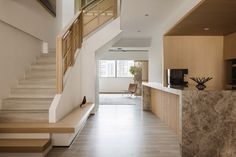 a long hallway with stairs leading up to the second floor and another room on the other side