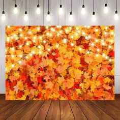 an image of fall leaves with lights on the wall in front of it and wood flooring