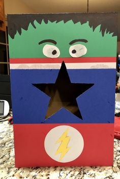 a cardboard box with the face of a man in a superhero costume on top of it