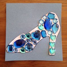 a piece of art made to look like a shoe with blue and green stones on it