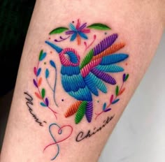 a colorful bird tattoo on the leg with words written below it and an image of a dragon