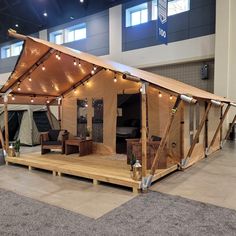 a wooden structure with lights on it in the middle of an indoor space that is lit up