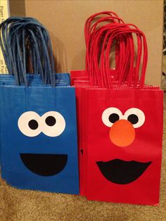 two bags decorated like sesame street characters with eyes and nose, one is red and the other blue