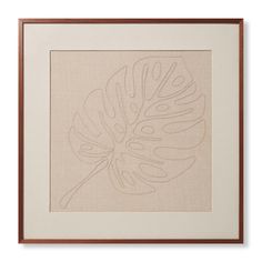 a framed art print with a large leaf on it's left side, in brown and white