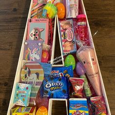 a wooden box filled with lots of different types of candy and candies on top of a table