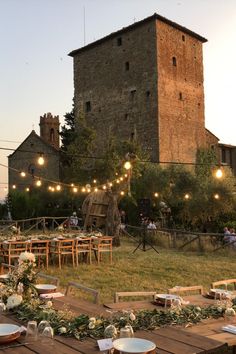 A beautifully set table for wedding guests at an Italian castle. The sun is beginning to set and string lights are on overhead. Italian Castle Wedding, Tuscan Castle, Tuscany Italy Wedding, Wedding Throw, Italian Castle, Pizza And Pasta, Pasta Making, Castle Wedding Venue, Wedding In Tuscany