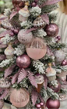 a pink christmas tree with ornaments on it