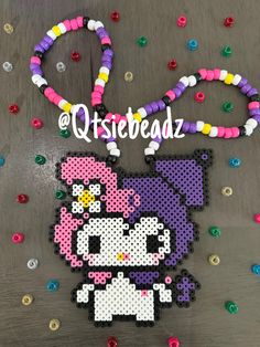 the hello kitty beaded necklace has been made with beads and is hanging on a table