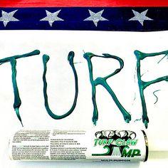 a tube of toothpaste with the word turf painted on it next to an american flag