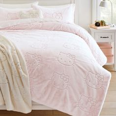 a pink hello kitty comforter set on a bed