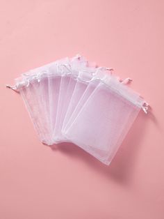 five clear bags are sitting on a pink surface