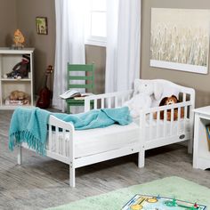 a child's bedroom with white furniture and decor