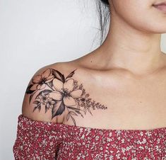 a woman with a flower tattoo on her upper arm and shoulder is looking at the camera