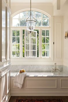 a bath room with a large window and a rug