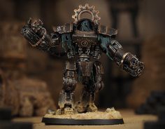 a warhammer is standing on a table with his hands in the air and holding two gears