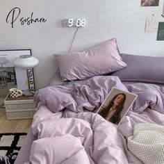 an unmade bed with purple comforter and pictures on the wall above it in a bedroom