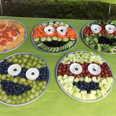 four plates filled with fruit and veggies in the shape of faces