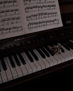 a piano with sheet music on it and a dog's head resting on the keys