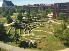 an aerial view of a circular garden in the middle of a park with rocks and trees