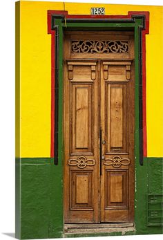 an old wooden door in front of a yellow and green wall