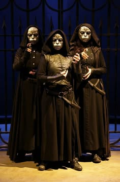 three people dressed in black and white are posing for the camera with their faces painted like skeletons