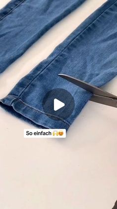 someone is cutting the jeans with scissors