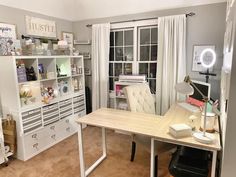 a room with a desk, bookcases and other items on it in front of a window